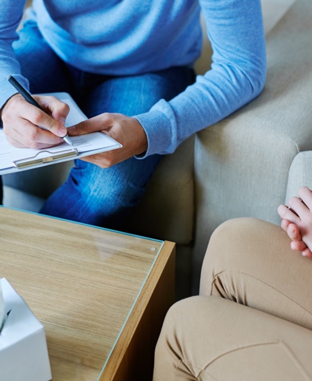 Psychiatrist sitting at a table with a patient.