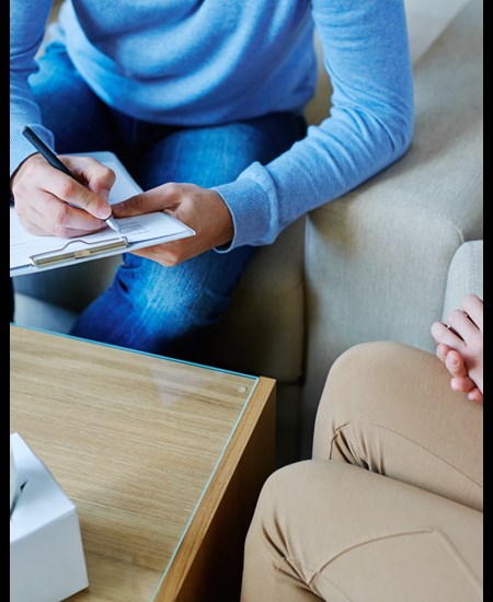 Psychiatrist sitting at a table with a patient.