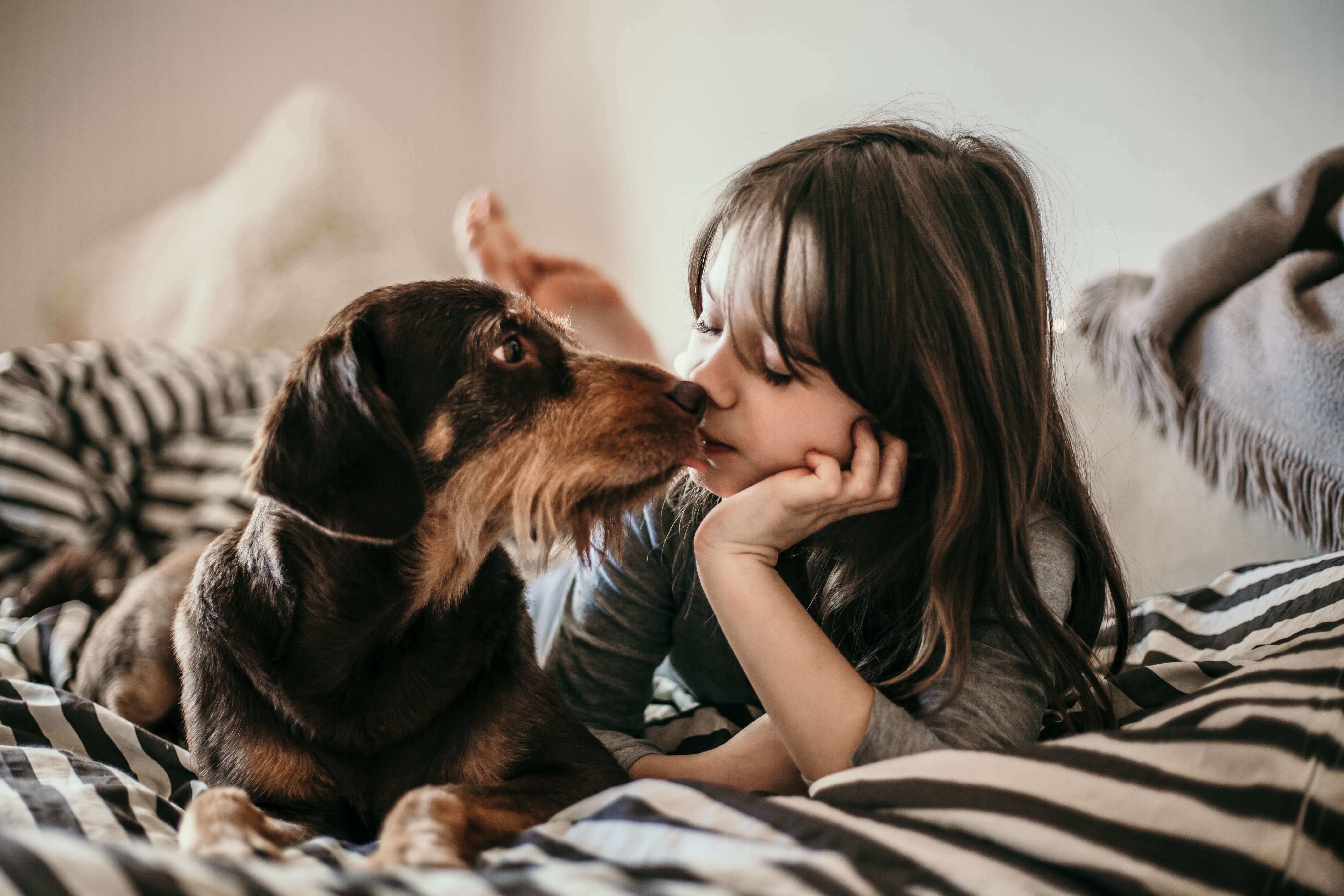 young girl laying in bed with her dog