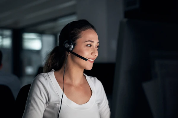 Woman with a headset typing on the computer