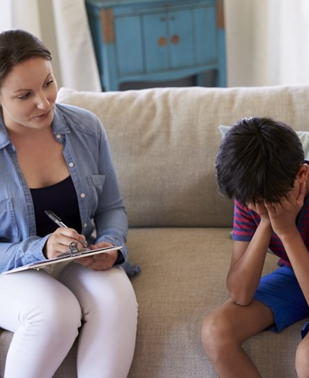 Child sitting with counselor on a couch