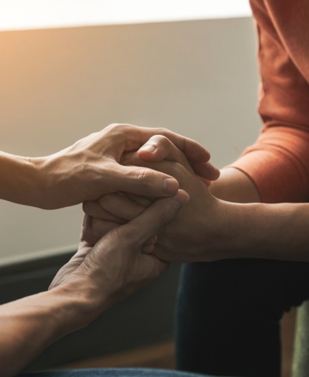 Counselor and patient holding hands.