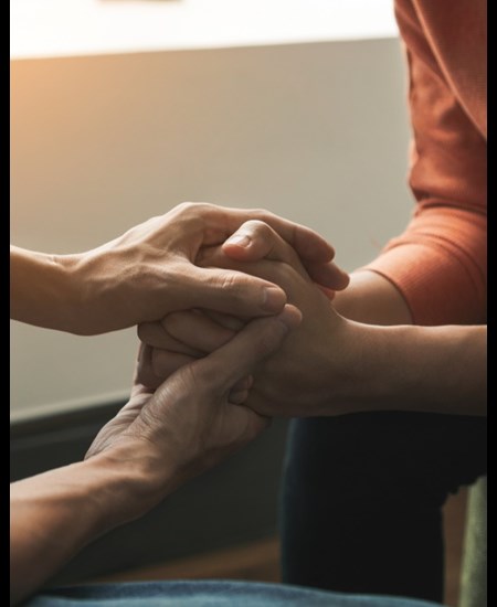 Counselor and patient holding hands.