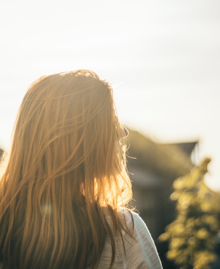 Back of girls head with sunlight in front of her