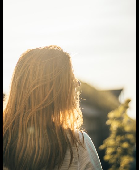 Back of girls head with sunlight in front of her