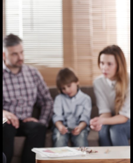Mom, dad, child all sitting together talking to a counselor